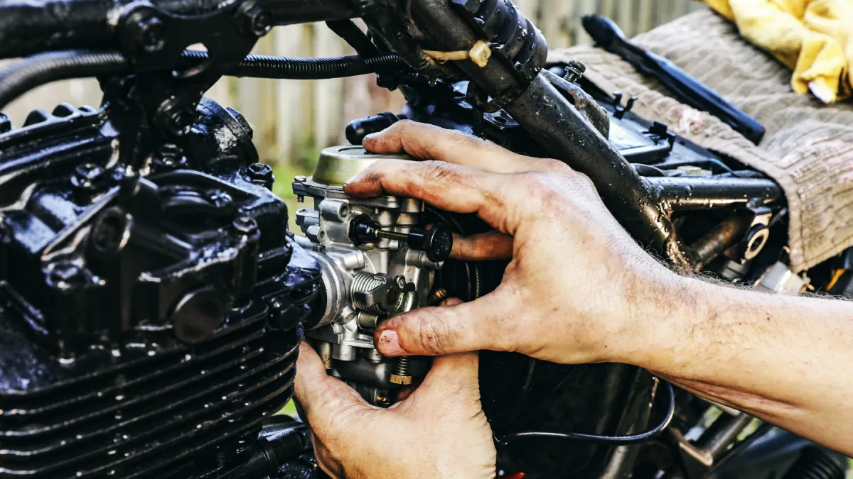 Närbild på en motorcykelmotors cylinder och en slagvolymsmärkning på bensintanken.