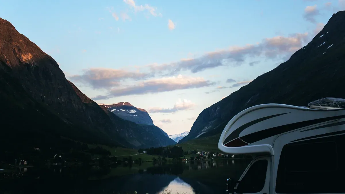 Husbil parkerad vid en sjö i skymning